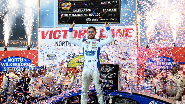 Kyle Larson (5) celebrates in Victory Lane after winning the...