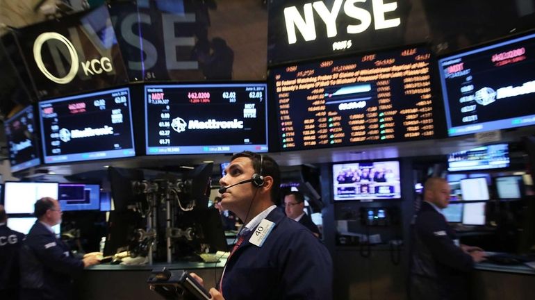 Traders work on the floor of the New York Stock...