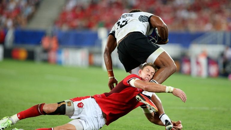 Fiji's Ilaisa Droasese evades a tackle by Wales' Liam Williams...