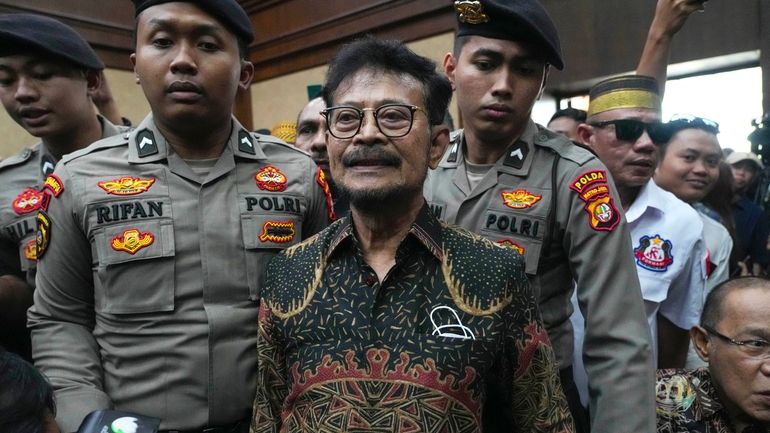 Former Indonesian Agriculture Minister Syahrul Yasin Limpo, center, is escorted...