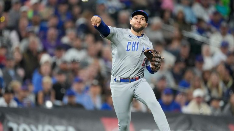 Chicago Cubs third baseman Nick Madrigal throws to first base...