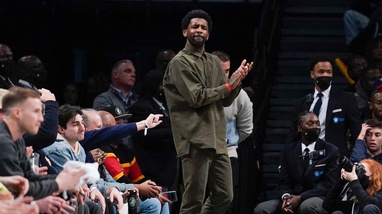 Nets' Kyrie Irving watches the game from his seats during...