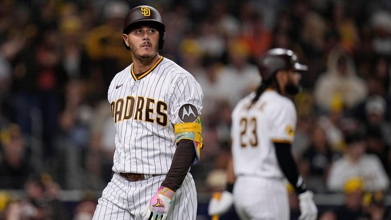 San Diego Padres' Manny Machado, left, passes teammate Fernando Tatis...