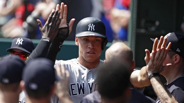 Aaron Judge celebrates with teammates after scoring the game-winning run...