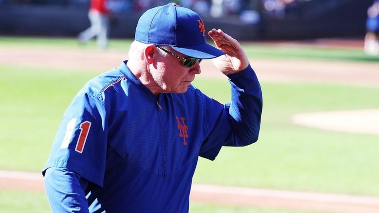 Mets manager Buck Showalter walks off the field and salutes...