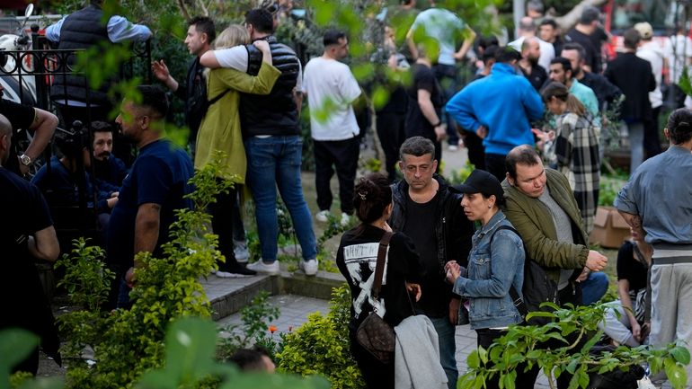 FILE -People gather as firefighters and medical teams work after...