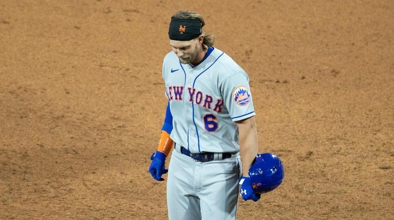 Jeff McNeil #6 of the Mets walks off the field after...