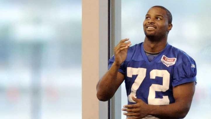 New York Giants' Osi Umenyiora tosses a football as he...