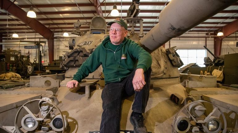 Mark Renton, director of the Museum of American Armor, sits...