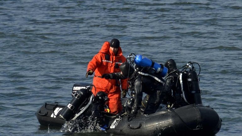 Police divers continue to search the East River in Queens...