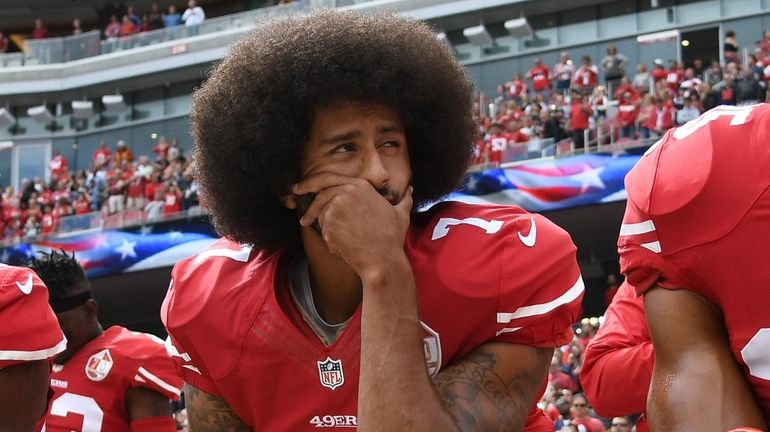 Colin Kaepernick kneels on the sideline during the anthem prior to...