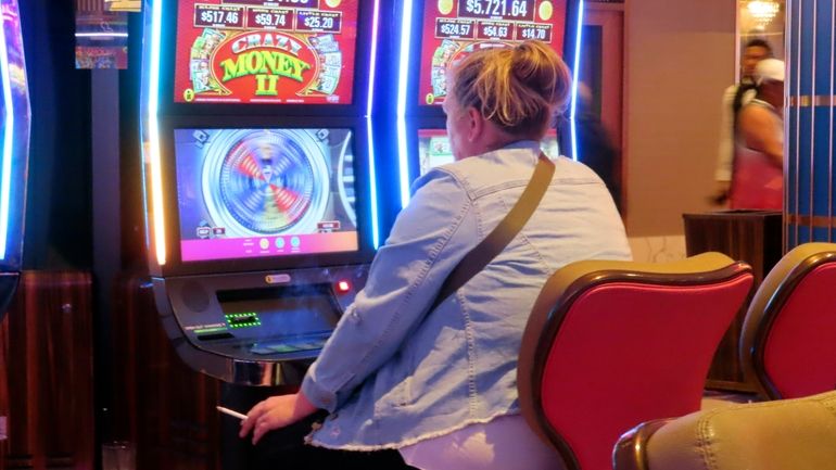 A gambler plays a slot machine at the Hard Rock...