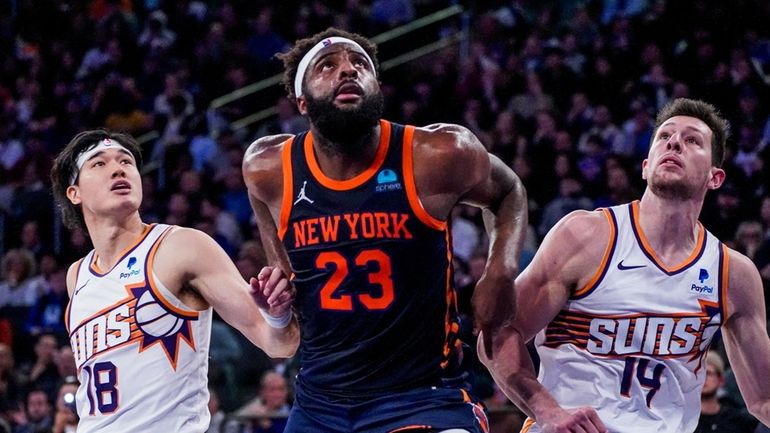 Knicks center Mitchell Robinson (23) fights for rebounding position against...