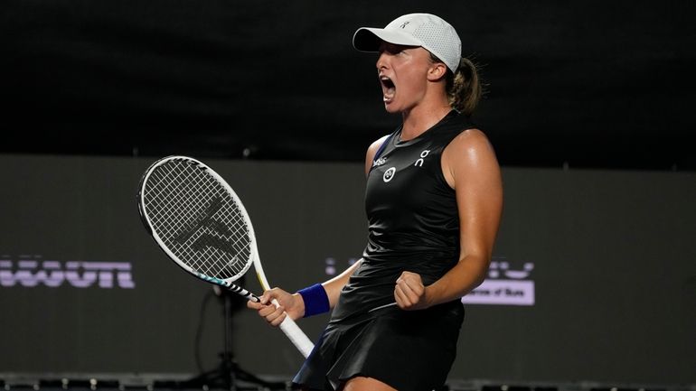 Iga Swiatek, of Poland, celebrates after defeating Aryna Sabalenka, of...