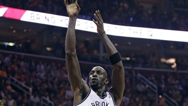 Kevin Garnett shoots over the Cleveland Cavaliers' Anderson Varejao and...