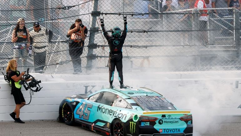 Tyler Reddick, center, celebrates on the track after winning a...