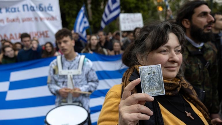 A protester holds a Holy Icon during a rally against...