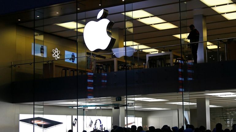 People wait in front of the Apple store in Munich,...