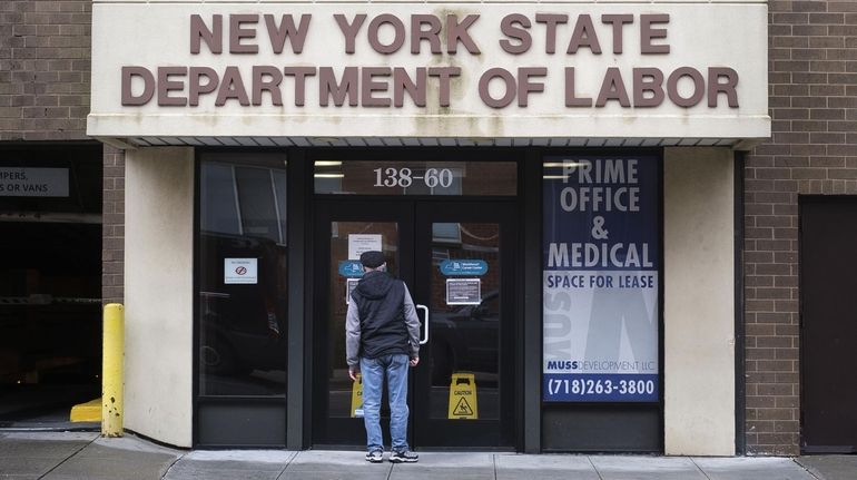 A person reads a sign on the door of a New...