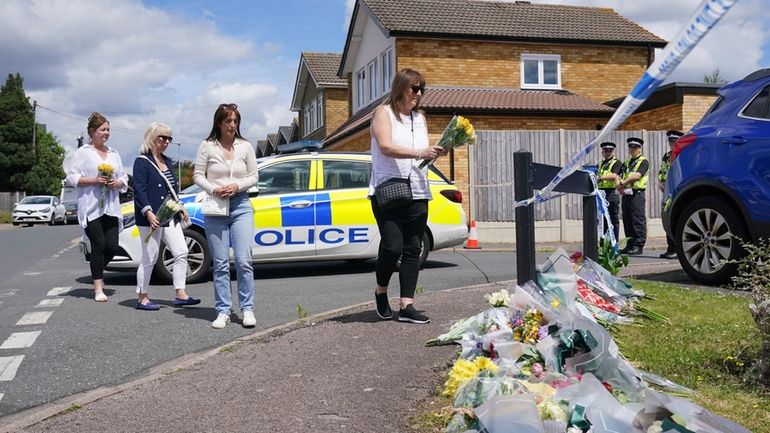 Family friend Lea Holloway, left, arrives with others to place...