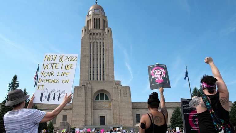 Protesters line the street around the front of the Nebraska...