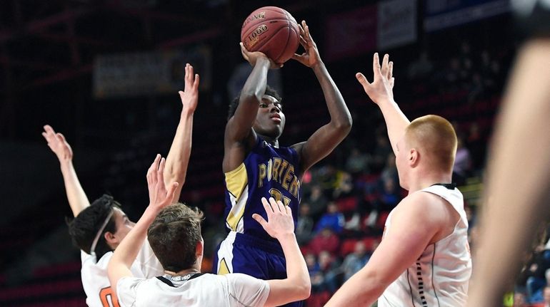 Greenport's Ahkee Anderson takes a shot over three Cooperstown defenders...