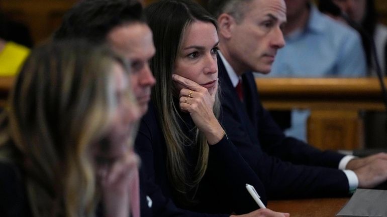 Karen Read, second from right, listens to testimony by witness...