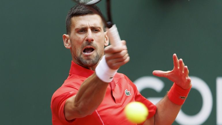 Serbia's Novak Djokovic returns a ball to Germany's Yannick Hanfmann...