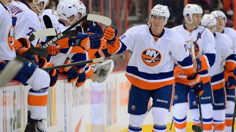 Islanders player Brock Nelson skates past the bench for hi-fives...