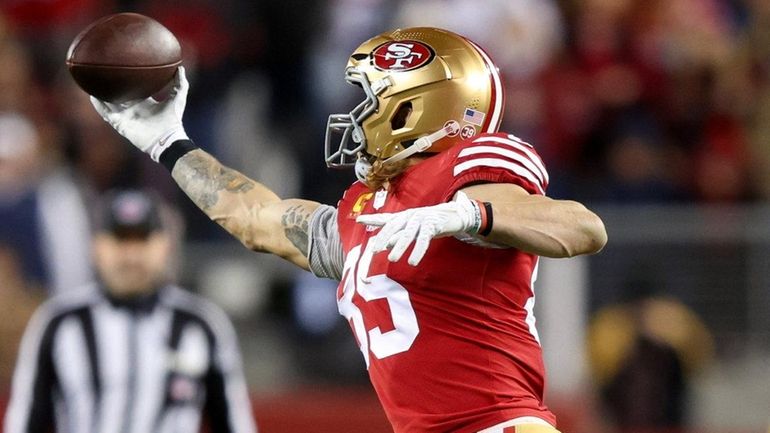 George Kittle of the 49ers catches a pass against the Cowboys...