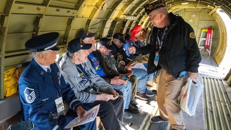 Veterans take their seats aboard a vintage C-47 aircraft before...