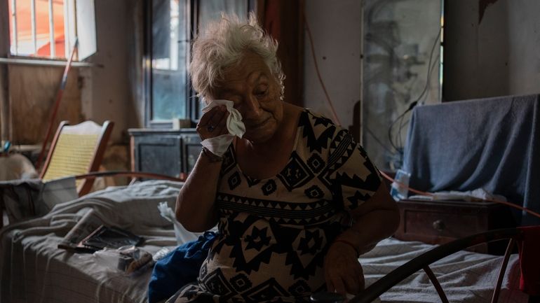 Margarita Salazar, 82, wipes the sweat off with a tissue...