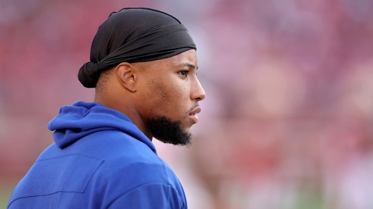 Saquon Barkley of the Giants looks on from the sideline against...