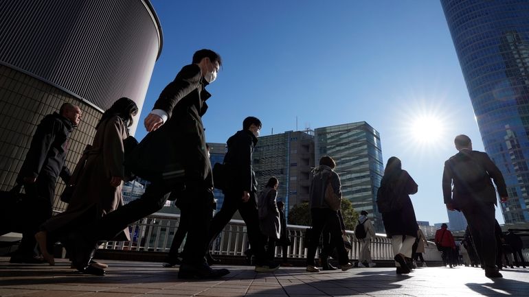 Commuters walk in a passageway during a rush hour at...