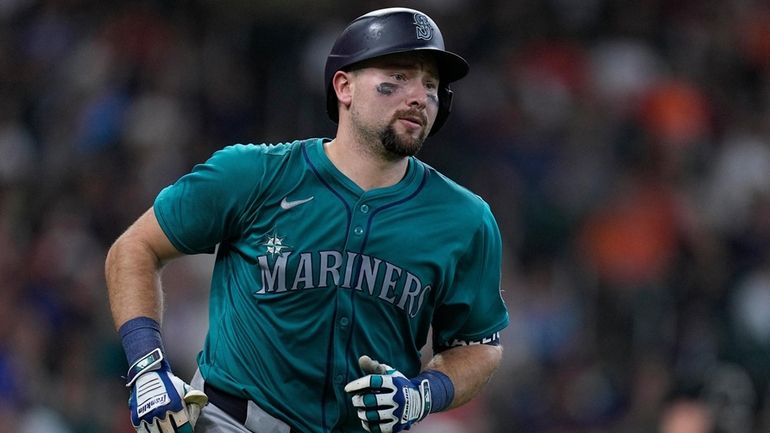 Seattle Mariners' Cal Raleigh runs the bases after hitting a...