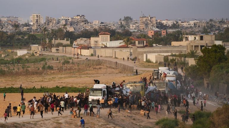 Palestinians are storming trucks loaded with humanitarian aid brought in...