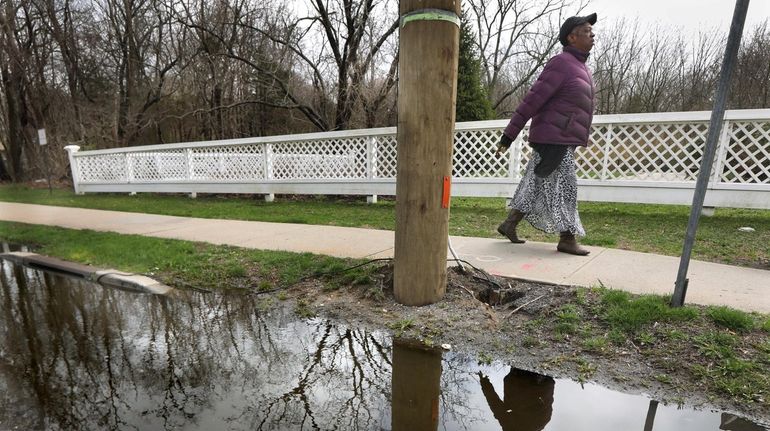 A pedestrian walks along Route 25 in Coram as clouds began...