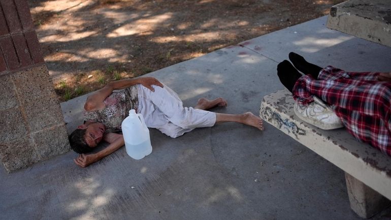 Deb Billet, 66, lies on the ground while Henderson Public...