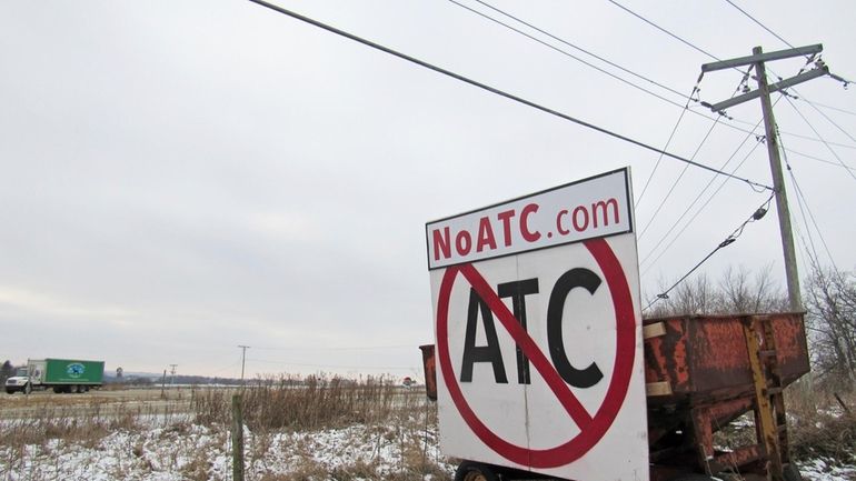 A grain wagon supports a sign against the proposed transmission...