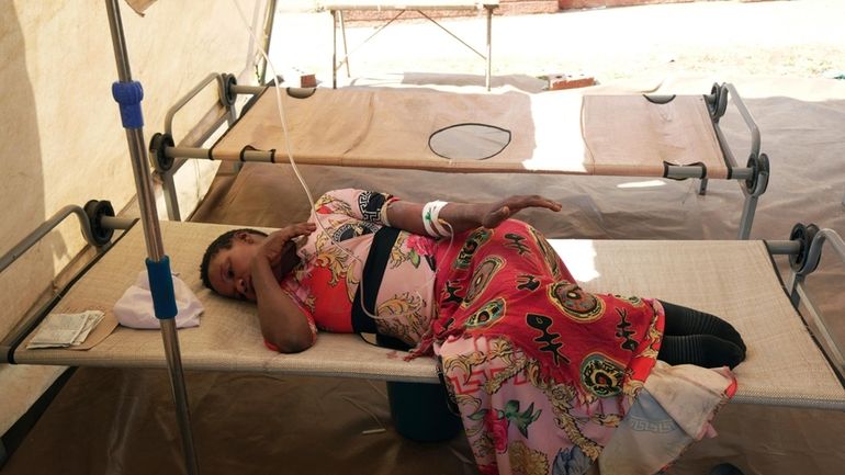 A cholera patient lies on a hospital bed, in Harare,...