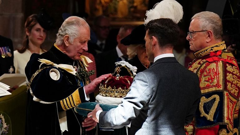 Britain's King Charles III is presented with the Crown of...