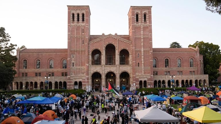 Demonstrators walk in an encampment on the UCLA campus, the...