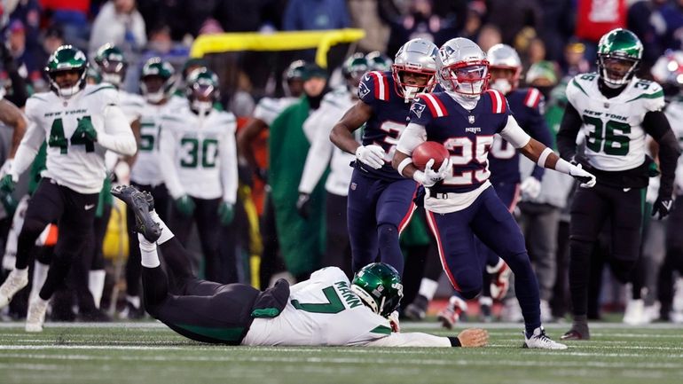 Patriots cornerback Marcus Jones runs past Jets punter Braden Mann, left, on...