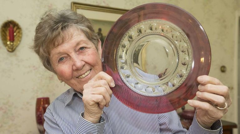 Ann Marie Mullen, who frequents tag sales, holds up cranberry...