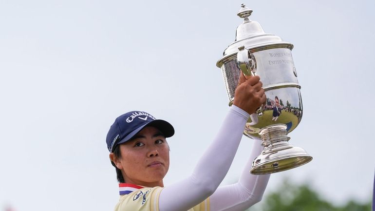 Yuka Saso, of Japan, holds the tournament trophy after winning...