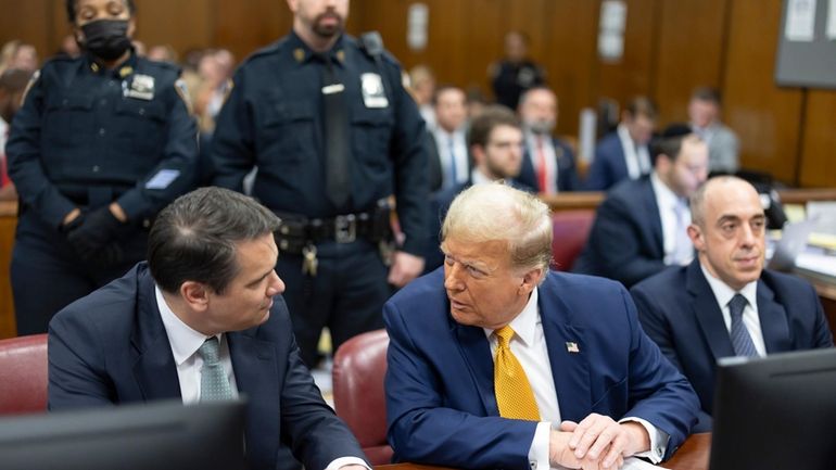 Former President Donald Trump, center, talks with his attorneys Todd...