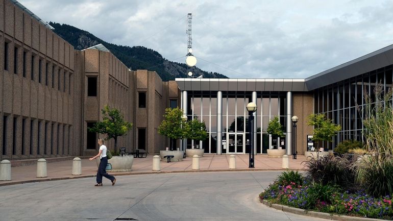 A woman walks in front of the Boulder County Justice...