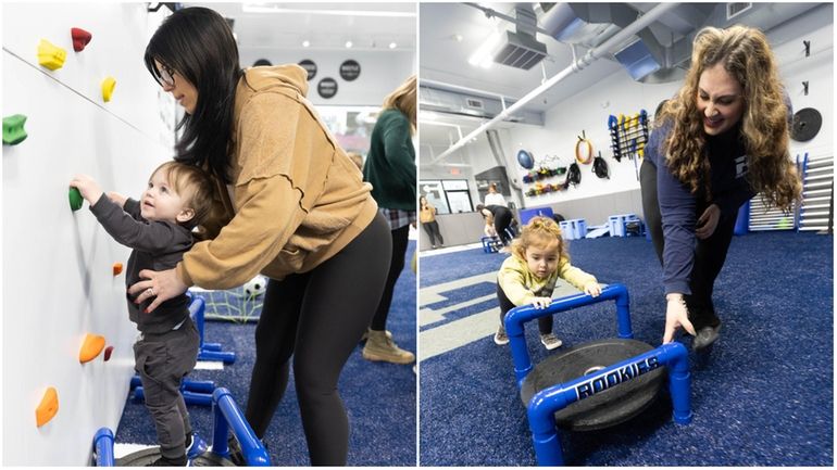 Sadie Loesch, 2, pushes a sled with the help of...