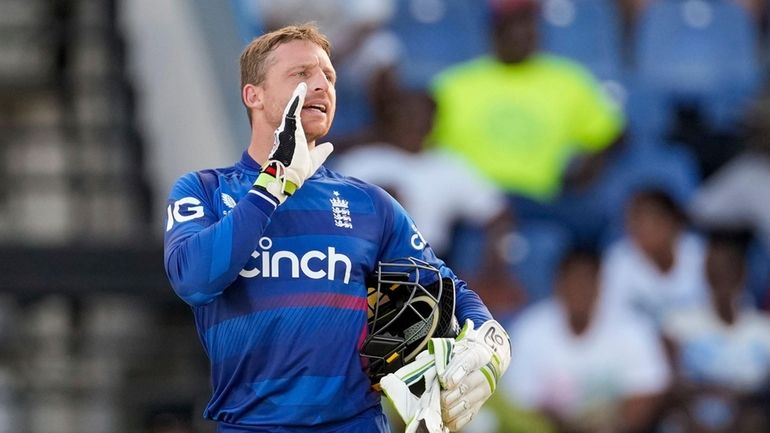 England's captain Jos Buttler talks to teammates during the first...