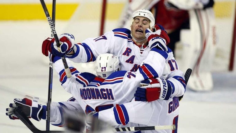 New York Rangers' Ryan McDonagh, bottom left, celebrates his overtime...